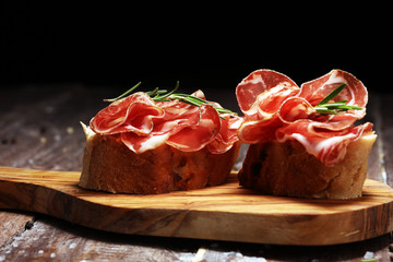 Italian sliced cured coppa with spices. Raw ham. Crudo or jamon with rosemary