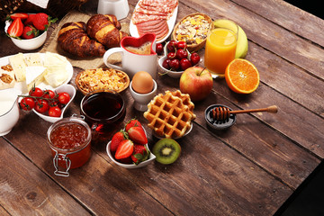 Breakfast served with coffee, orange juice, croissants and strawberry, jam and tea. breakfast table