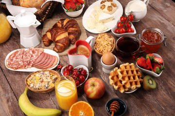 Breakfast served with coffee, orange juice, croissants and strawberry, jam and tea. breakfast table
