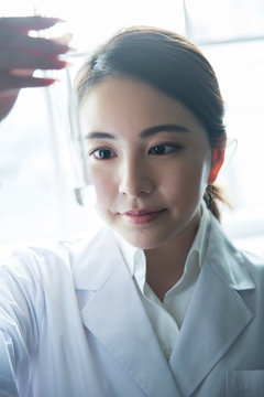 試験管の中の液体の様子を確認する20代研究員