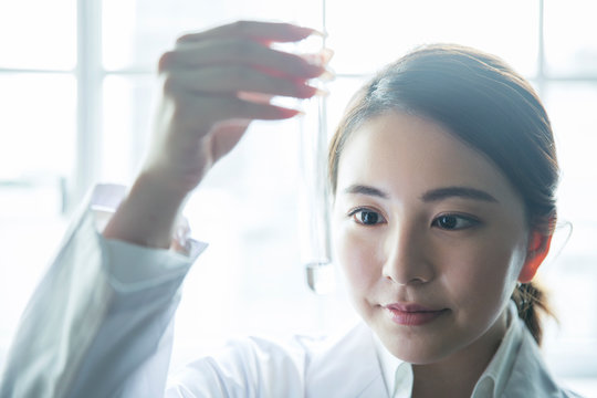 試験管の中の液体の様子を確認する20代研究員