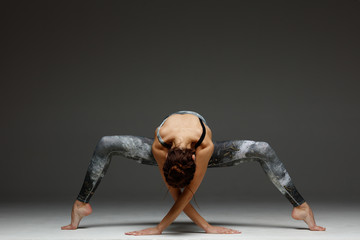 Young beautiful yoga instructor is posing in studio.