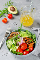 Healthy salad bowl with chicken, mushrooms, tomatoes, cucumbers, avocado and arugula