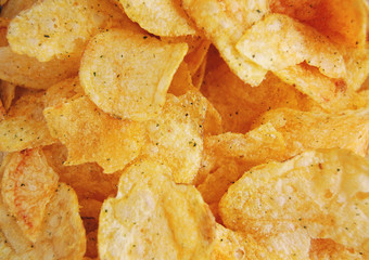 .Golden crispy potato chips macro background.