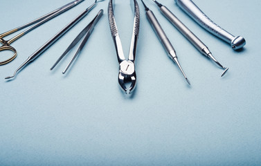 Closeup of dental metal tools on light blue background