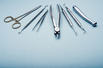 Dental steel instruments on light blue background with copy space