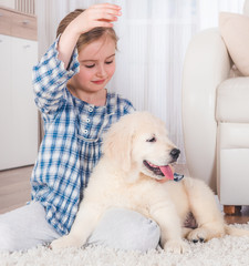 Little girl playing with cute fluffy retriever puppy