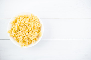 various types of pasta on a white wooden table. Italian cuisine concept, food ingredients. Flat lay. Top view, copy space