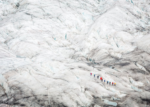 People walking on ice on glacier melting