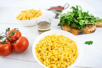various types of pasta on a white wooden table. Italian cuisine concept, food ingredients. Close up view