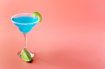 Blue margarita exotic alcoholic cocktail with tequila, liqueur, lime juice, salt and ice, summer blue background, place for text