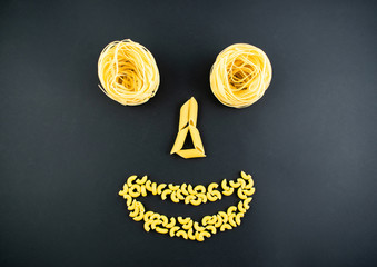 various types of pasta on a dark background. Italian cuisine concept, food face. Flat lay. Top...