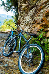 Fototapeta na wymiar black mountain bikes by the huge brown rock