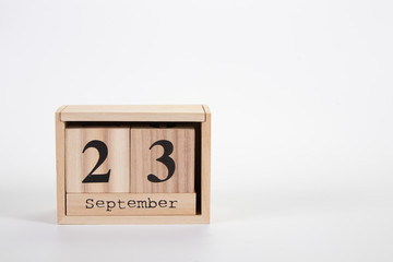 Wooden calendar September 23 on a white background