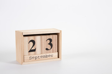Wooden calendar September 23 on a white background
