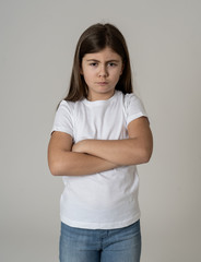 Pretty little girl with angry facial expression looking mad at the camera. Human emotions