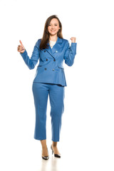 Happy businesswoman standing on white background and showing thumbs up