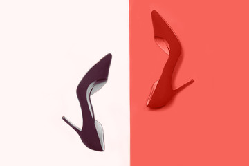 Female stylish accessories fashion luxury outfit set: red shoes and dark purple color in coral color background. Christmas New Year Valentine's day Party concept. Flat lay, top view, copy space.