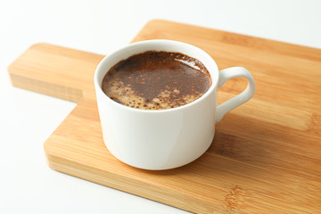 Cutting board with cup of fresh coffee on white background, space for text