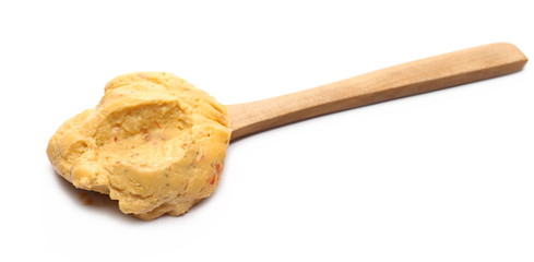 Spicy hummus, piquant spread with wooden spoon, isolated on white background