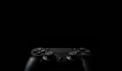 Modern black gamepad on a dark background. Game concept with copy space for text or design. © solidmaks