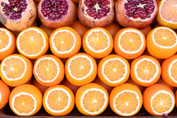 Fototapeta na wymiar Oranges and pomegranates cut in half ready for juicing. Street market, Istanbul