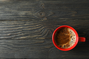 Cup of coffee with frothy foam on wooden background, space for text and top view. Coffee time accessories