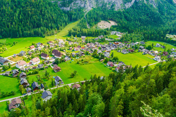 Fototapeta na wymiar Aerial view of Hallstatt village with tiny houses, as seen from the difficult (rated black) Echernwand klettersteig/via ferrata route on a sunny day in Summer. Popular tourist activity in Austria.