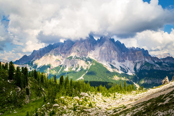 Monte Cristallo in Dolomites mountains, Italy, with big white clouds, as seen from a hiking trail towards Forcella Marcoira and Lago di Sorapis, during Summer. Breathtaking scenic views in the nature.