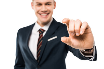 selective focus of happy businessman gesturing and smiling isolated on while