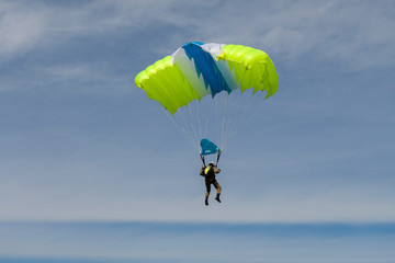 Skydiving. A parachute is in the sky.