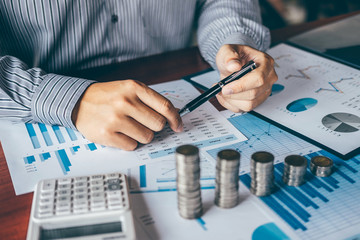 Businessman accountant counting money and making notes at report doing finances and calculate about cost of investment and analyzing financial data, Financing Accounting Banking Concept