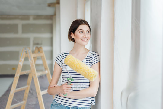 Woman admiring the newly painted wall in her house