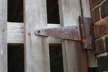 Rusty metal latch on old weathered wooden gate