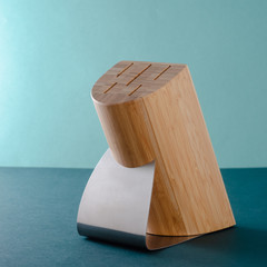 Woman Hands Pulling Out Stainless Steel Chef's Knives From A Bamboo Stand