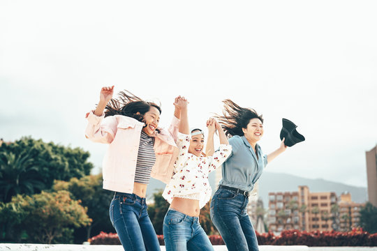 Happy Asian Girls Jumping Together Outdoor - Young Women Friends Having Fun During University Break Dancing And Celebrating Outside - Millennial Generation, Friendship And Youth People Lifestyle