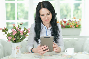 Portrait of beautiful blonde young woman using tablet