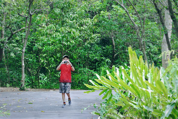 Boy with Casual Clothing Taking Photos of Scenery with Compact Camera