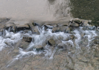 Wasser fließt über Steine in einem Fluss