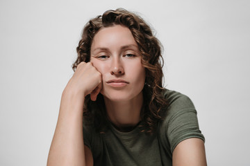 Displeased tired sleepy curly woman, propping his cheek, looking bored © Arsenii