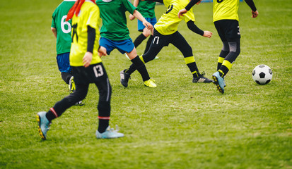 Naklejka na ściany i meble Soccer background. Players kicking soccer ball on green field. Football tournament match game for youth teams