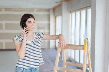 Young woman decorating a house chatting