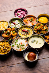 assorted Indian/Pakistani food in stainless steel bowls creating pattern or design, selective focus