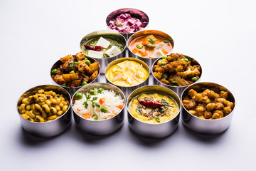 assorted Indian/Pakistani food in stainless steel bowls creating pattern or design, selective focus