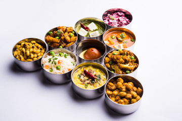 assorted Indian/Pakistani food in stainless steel bowls creating pattern or design, selective focus