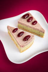 Sliced of Red bean cheese cake on white plate on red Background.