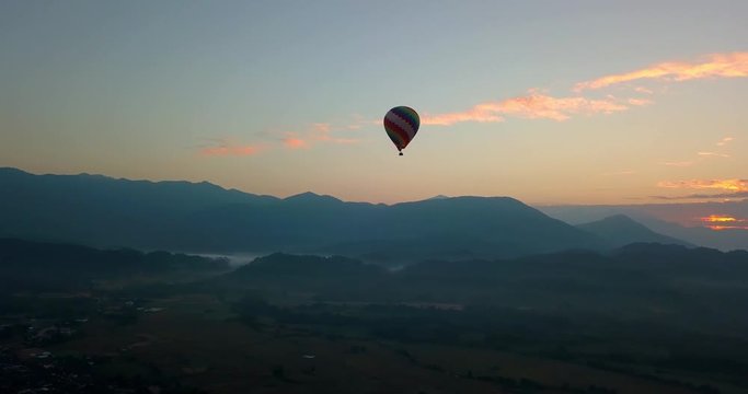 beautiful sunrise with hot air balloon flying over the mountains in Vang Vieng, Laos