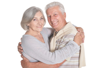 Portrait of happy senior couple hugging on white background