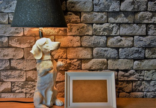 table lamp white dog figurine and photo frame on gray bricks wallpaper background
