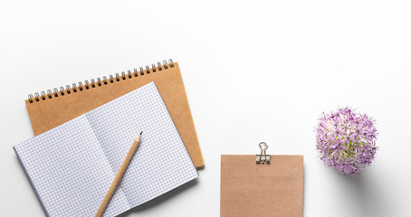 office desk workspace with blank copy space and nice flowers decoration. mockup notebook on white background. Flat lay, top view modern minimalist blog template